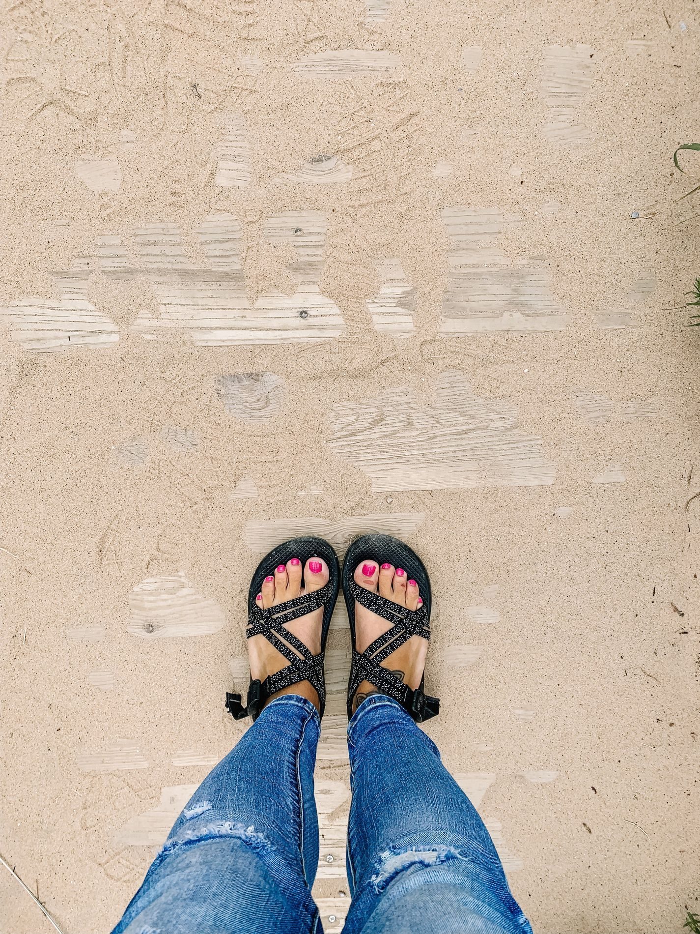Standing on a sandy boardwalk by the water