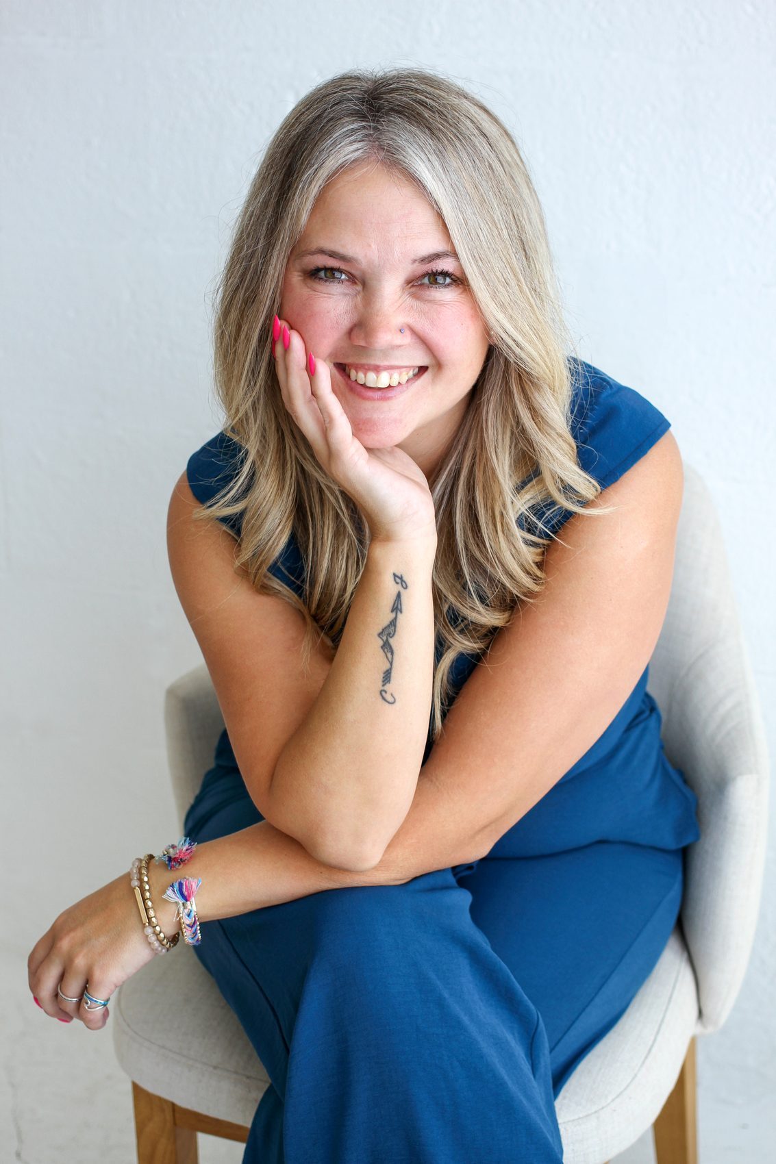Samantha smiling, phone in hand, in a bright studio