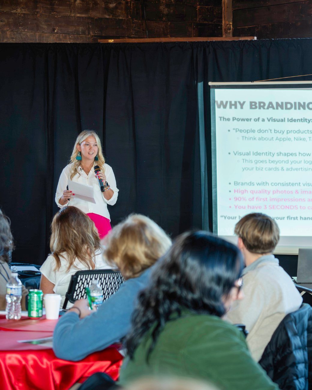 Samantha on stage with a microphone during a talk