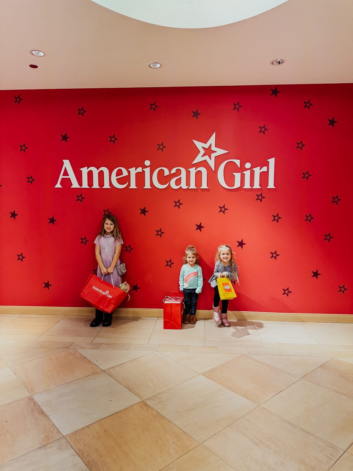 Three girls with their shopping bags at American Girl Place
