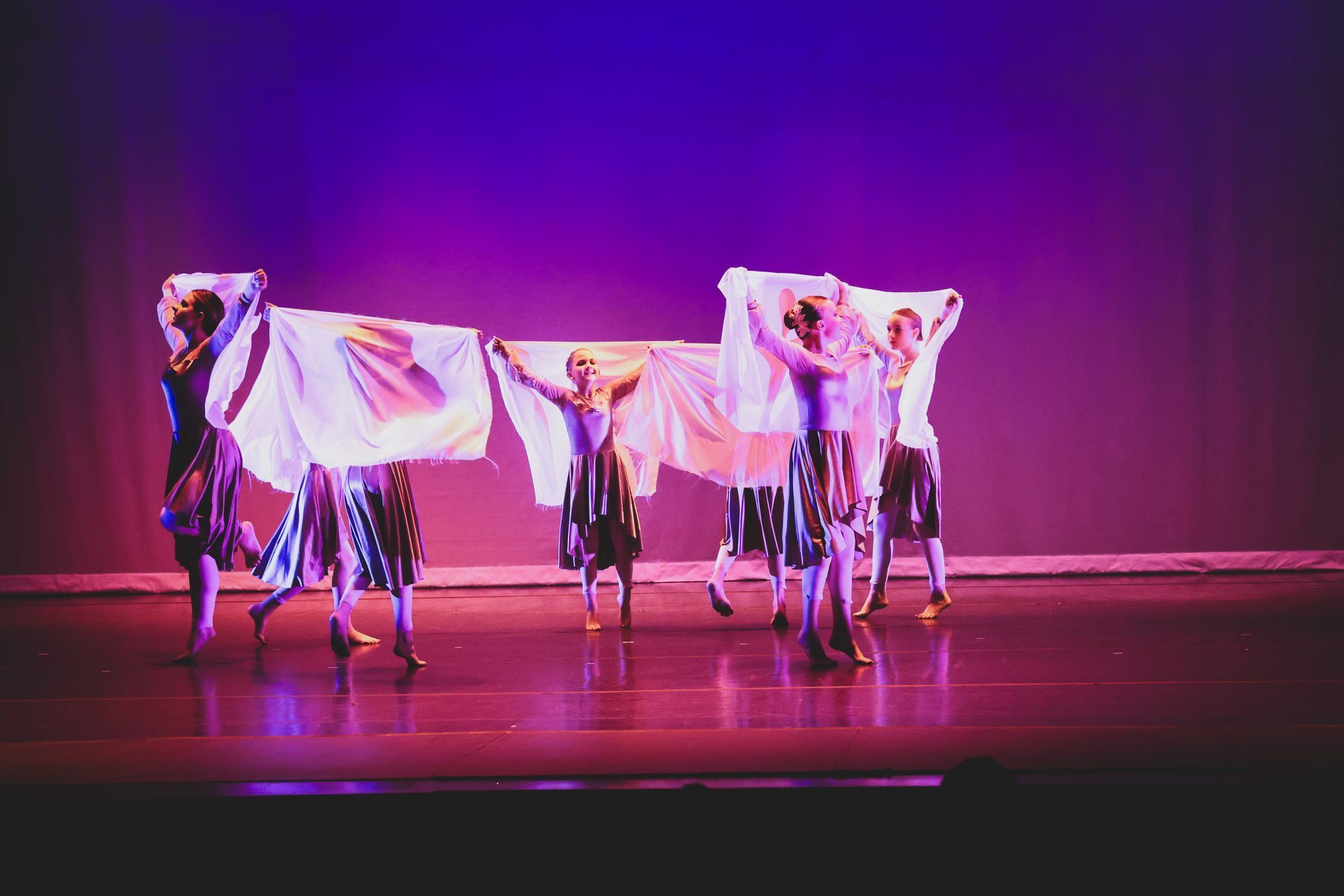 A line of Sanctuary dancers on stage under stage lights